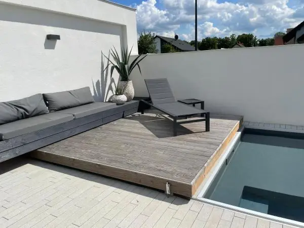 <p>Designové dvou segmentové pochozí zastřešení pro moderní dům. Dva segmenty se odsouvají od sebe, přičemž jeden segment se odsouvá pod relaxační lavici a vytváří tím odpočinkovou terasu pod dřevěnou lavicí. Toto zastřešení svým designem skvěle zapadá do koncepce moderního domu. Povrch bazénového krytu je obložen dřevěnými terasovými prkny Douglaska.</p>
