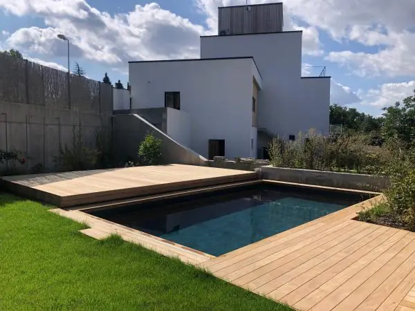 <p>Toto bazénové zakrytí je obloženo dřevěnými terasovými prkny Garapa a odsouvá se pomocí elektrického motoru. Při odsunu se zastřešení stává ideálním místem pro odpočinek a relaxaci u bazénu.</p>
