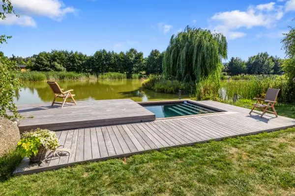 <h3>Neviditelný bazén na břehu rybníka</h3>

<p>Nádherný kryt bazénu u rybníka dotváří celý koncept, zvolený majitelem. Přilehlý roubený dům je vsazen do přírody, kde se vyjímá velký rybník s ostrůvkem. Bazén, který byl vytvořen na břehu rybníka, tak zakrývá zastřešení a vytváří dojem, že se zde nachází pouze dřevěné molo.</p>
