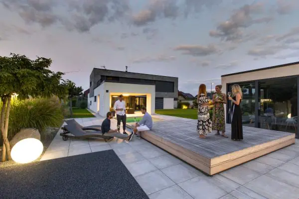 <p>Zastřešení v této realizaci se skládá ze 2 segmentů, přičemž menší segment zajíždí do většího segmentu. Opět se zde ukazuje, jak zastřešení ladí se zahradním konceptem a propojuje přírodu kolem s moderním designem domu. Majitelé domu využívají posuvné zastřešení taktéž jako slunnou terasu k odpočívání, či posezení s přáteli. Design zastřešení podtrhává exotické dřevo garapa.</p>